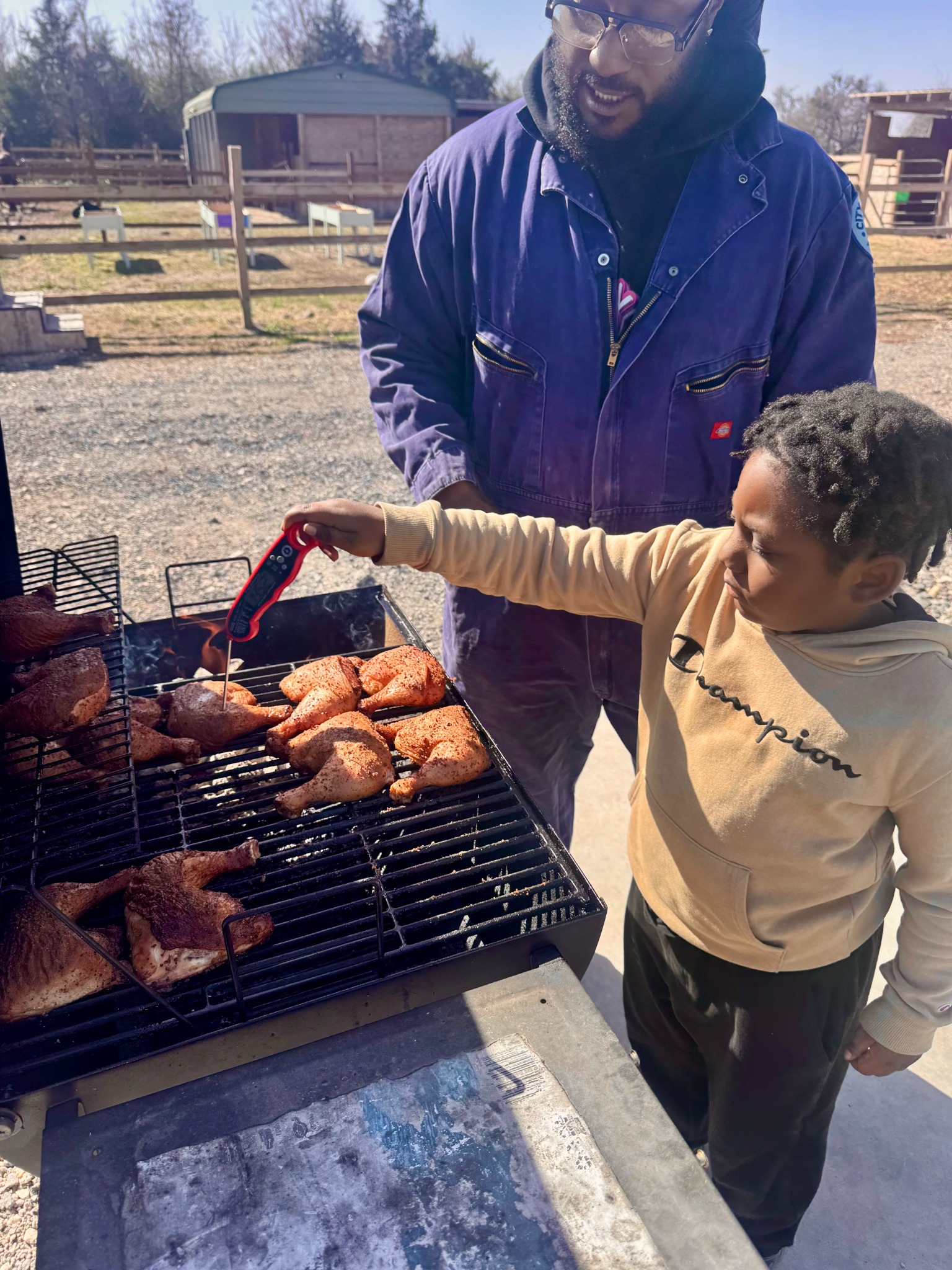 A child learning outdoor cooking at the grill
