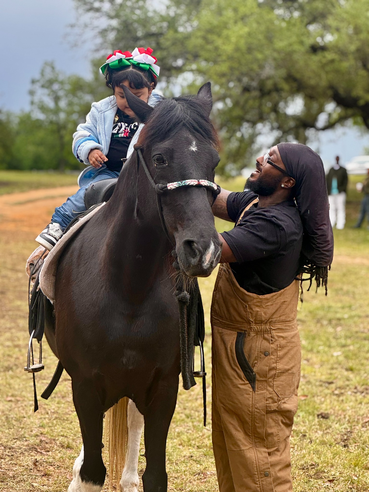 A child riding a horse with a volunteer beside them